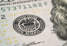 Fed King Dies — Now The Blame War Begins Close-up of a United States dollar bill featuring the Federal Reserve emblem
