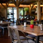 Interior of a cozy restaurant with wooden tables and decorative plants