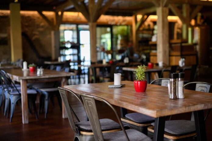 Modern,Restaurant,With,Wooden,Tables,,Chairs,,And,Flooring.,Ambient,Atmosphere, Interior of a cozy restaurant with wooden tables and decorative plants