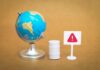 100M Barrels? Trump’s Covert Oil Gambit A miniature globe next to a warning sign and a barrel