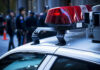 GPS Bombshell Restarts Murder Search Police car roof with lights, officers in background.