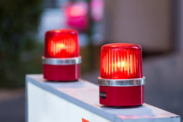 Two red warning beacons lit on a barrier