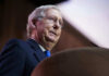 McConnell’s Month-Long Silence Sparks Alarm Mitch McConnell at a podium speaking.
