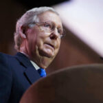 McConnell’s Month-Long Silence Sparks Alarm Mitch McConnell at a podium speaking.