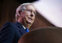 McConnell’s Month-Long Silence Sparks Alarm Mitch McConnell at a podium speaking.