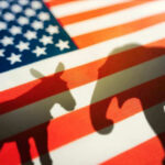Donkey and elephant silhouettes on American flag background.