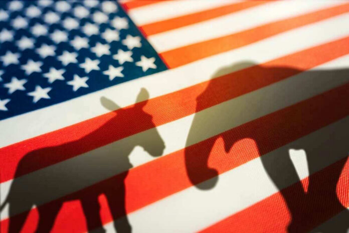 shutterstock_2193751699 Donkey and elephant silhouettes on American flag background.