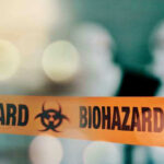 Salad Greens Blamed For Explosive Outbreak Biohazard tape with blurred figures in background.