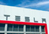 Tesla Trunk Horror: Judge Moves Forward Tesla building with logo against blue sky