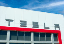 Tesla Trunk Horror: Judge Moves Forward Tesla building with logo against blue sky