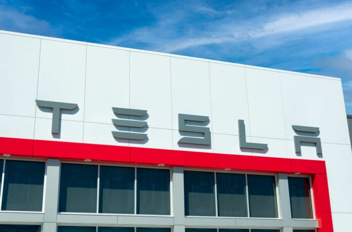 Tesla building with logo against blue sky