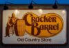 Cracker Barrel restaurant sign featuring a seated figure and a barrel