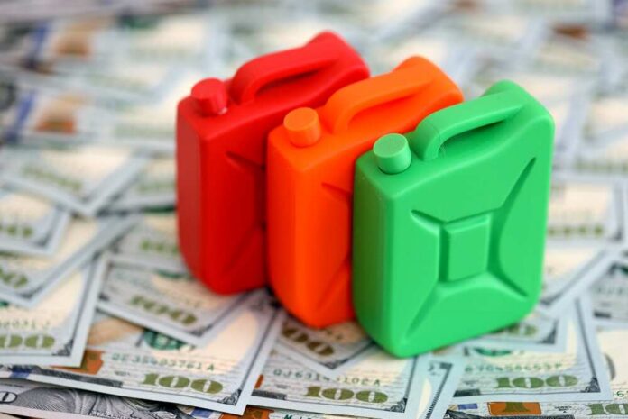Three colorful plastic containers on a background of hundred dollar bills