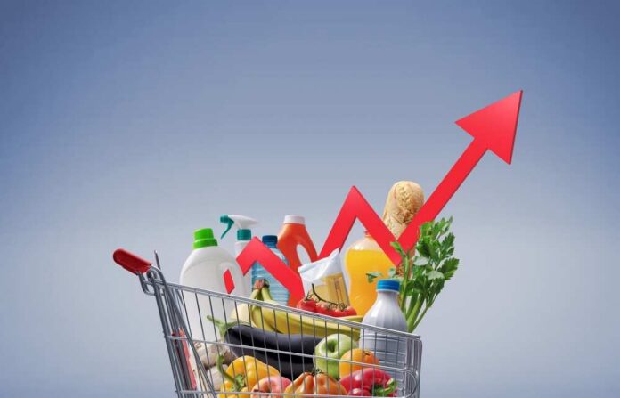 Concept,Image,Of,Rising,Grocery,Prices,With,A,Supermarket,Cart Shopping cart filled with various groceries in a supermarket aisle