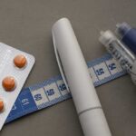 A prescription pad with a stethoscope and pills nearby
