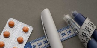 A prescription pad with a stethoscope and pills nearby