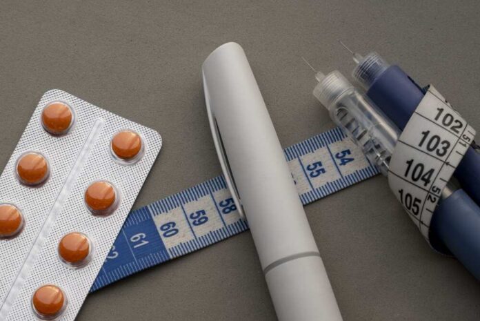 A prescription pad with a stethoscope and pills nearby
