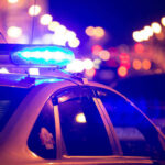 Mass Shooting Horror, No Arrests Police car with flashing blue lights at night.
