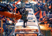 Robotic arms welding car bodies in an automotive factory.