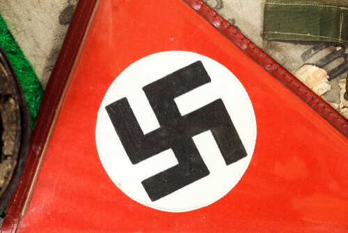 Close,Up,Of,A,German,Wwii,Swastika,On,A,Piece Close-up of a red flag featuring a black swastika symbol