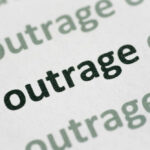 Rescuers Hit — Outrage Erupts Close-up of the word 'outrage' printed in bold on paper