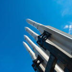 Missiles silhouetted against American flag background with sunset.