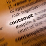Blurred dictionary entry focusing on the word 'contempt'