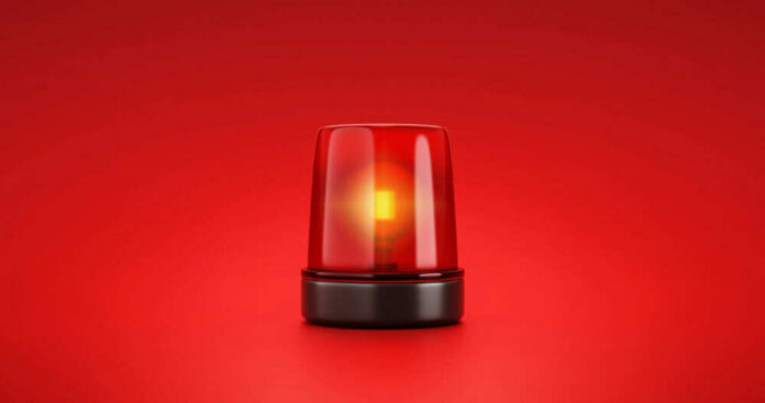shutterstock_2053758056 Red emergency light on red background