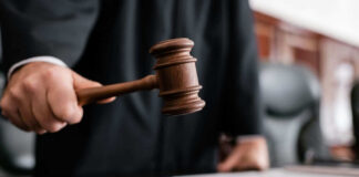 Judge holding gavel in courtroom.