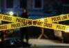 She’s DEAD – Manhunt Ends With Twist Police tape marking a crime scene with blurred figures in the background