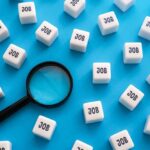 Magnifying glass among cubes labeled job on blue background
