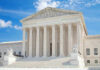 United States Supreme Court building with statues and columns.