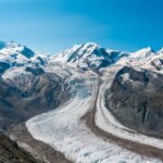 Vanished Climbers Emerge As Ice Retreats Blue glacier ice with crevasses and rocky surface
