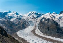 Blue glacier ice with crevasses and rocky surface