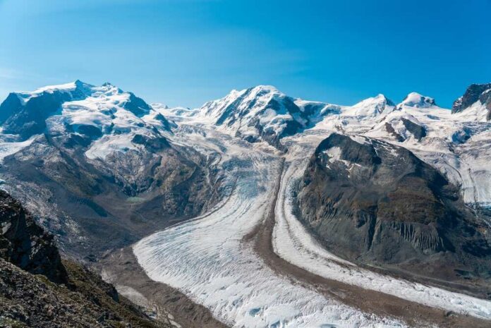Blue glacier ice with crevasses and rocky surface