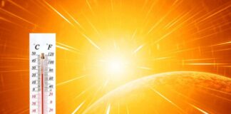 Thermometer displaying high temperature against a bright sun