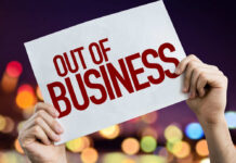 Hands holding an out of business sign