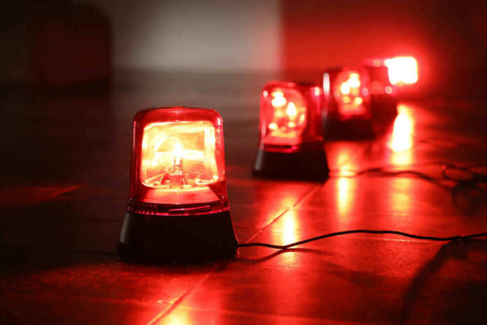 shutterstock_1042134532-1 Red emergency lights on dark floor, illuminating the area.