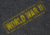 The words 'WORLD WAR II' printed in yellow on a dark asphalt surface
