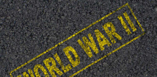 The words 'WORLD WAR II' printed in yellow on a dark asphalt surface