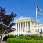 United States Supreme Court building with columns and an American flag