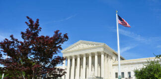 United States Supreme Court building with columns and an American flag