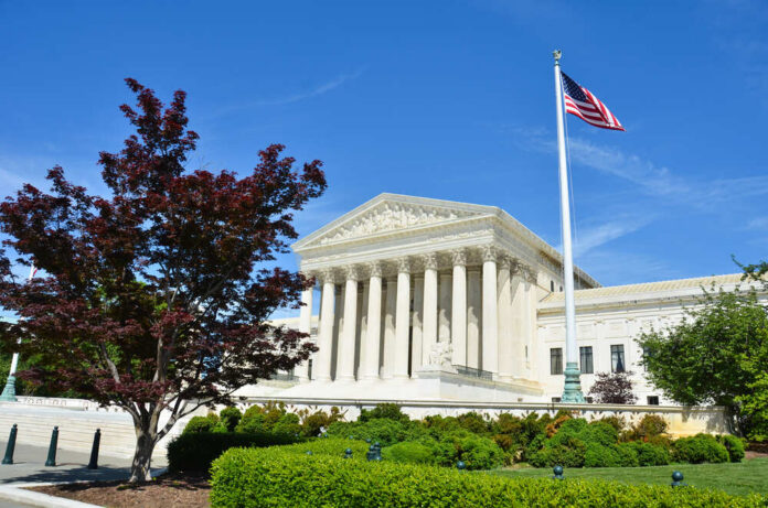 United States Supreme Court building with columns and an American flag