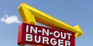 In-N-Out Burger sign with yellow arrow against blue sky