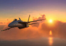 Fighter jet flying towards sunset over the ocean.