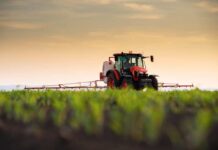 Diesel At $6 – Brace For Price Shock A tractor spraying crops in a field during sunset