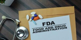 FDA document with pills and a stethoscope on a wooden surface
