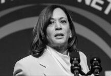 Kamala Harris speaking at a podium with microphones