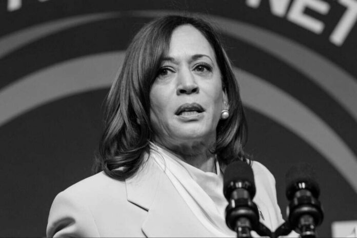 shutterstock_2289228675-modified Kamala Harris speaking at a podium with microphones