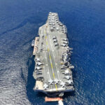 Aircraft carrier on open sea with parked planes